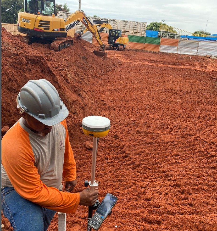 Técnico operando receptor GNSS RTK em canteiro de obras